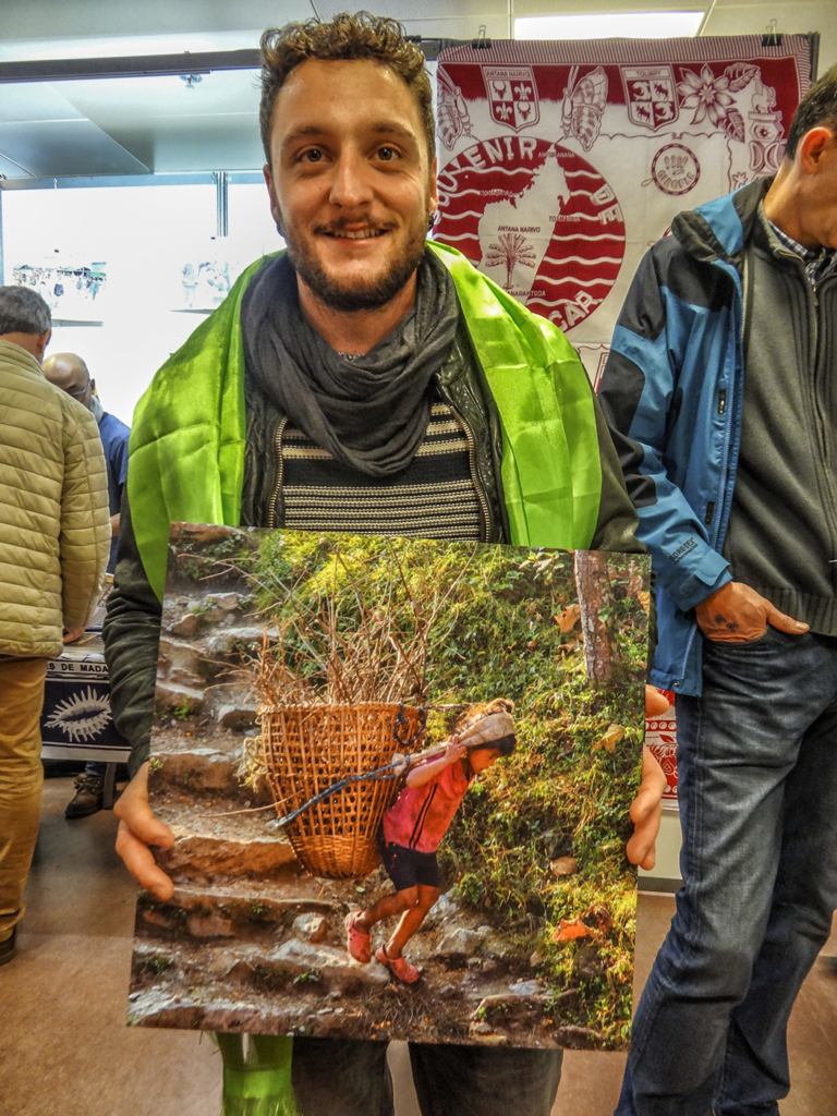 Vincent presents one of the photos for sale, taken in the village of Basa Rapcha